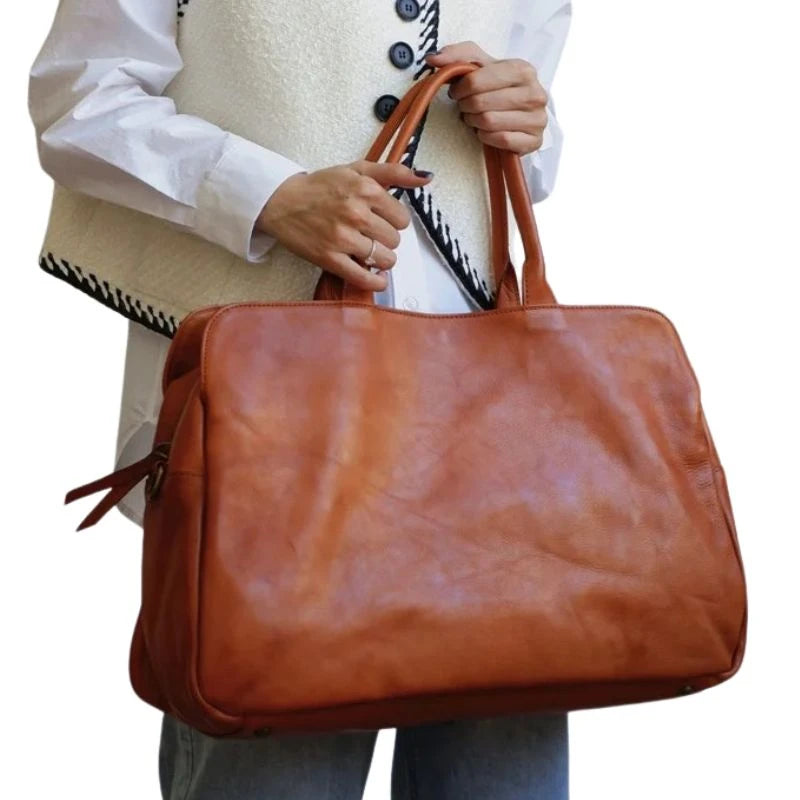 Woman holding an brown leather bag displaying a casual yet elegant style - variant.