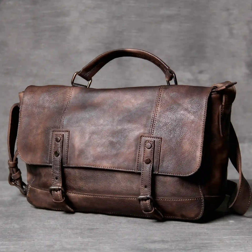 Brown leather bag with soft handle and adjustable strap, front view.