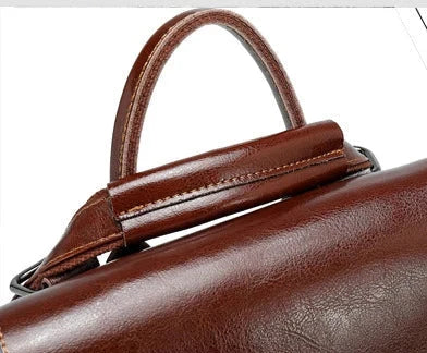 Close-up view of a stylish brown leather handbag with a sleek handle.