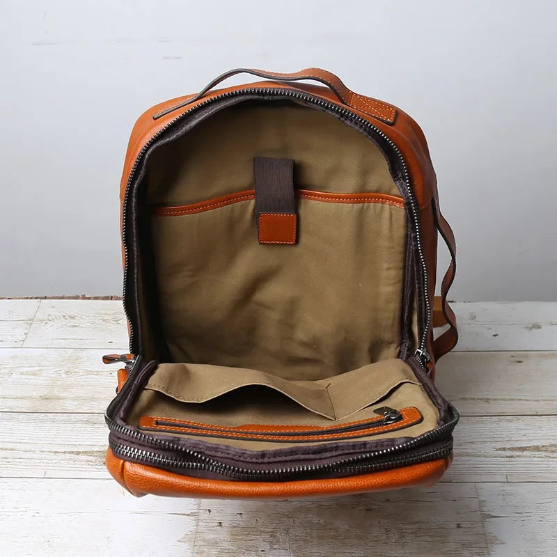 interior view of a brown leather backpack with spacious interior and organized compartments.