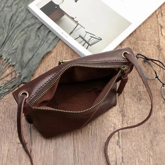 interior view of a brown leather crossbody bag with main zipper showcasing capacity.