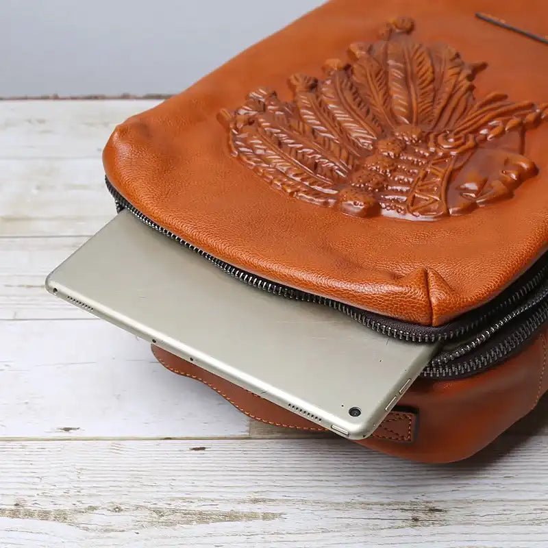 Close-up image of a stylized leather bag, with a laptop protruding from the top, highlighting the bag's functional design.