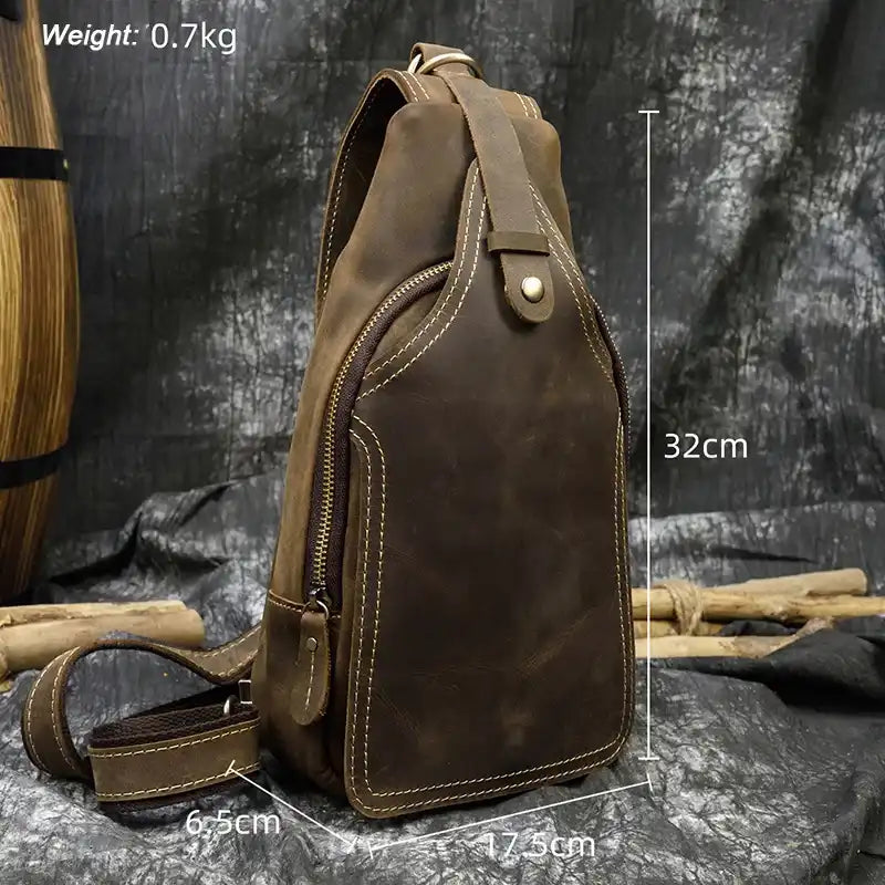 Brown leather sling bag measuring 32cm high, 17.5cm wide and 6.5cm deep, front view.