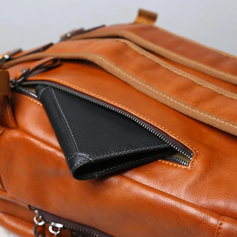 close-up of a brown leather backpack showing a side zippered pocket with wallet inside.