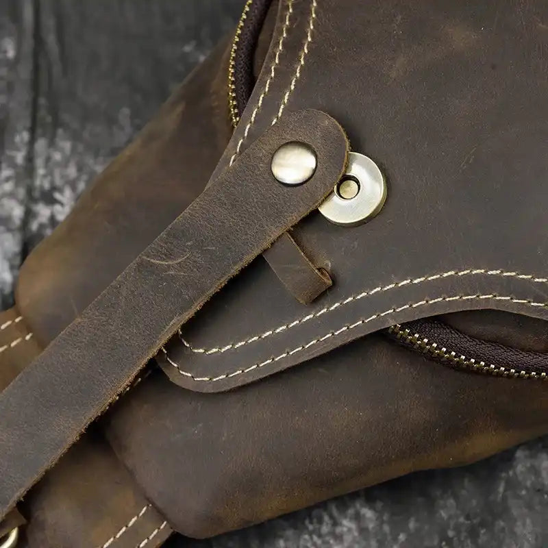 Detailed view of a brown leather bag, showing the closure and stitching. 
