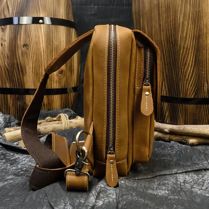 Brown leather bag, casual style, featuring large compartments and adjustable strap, side view.