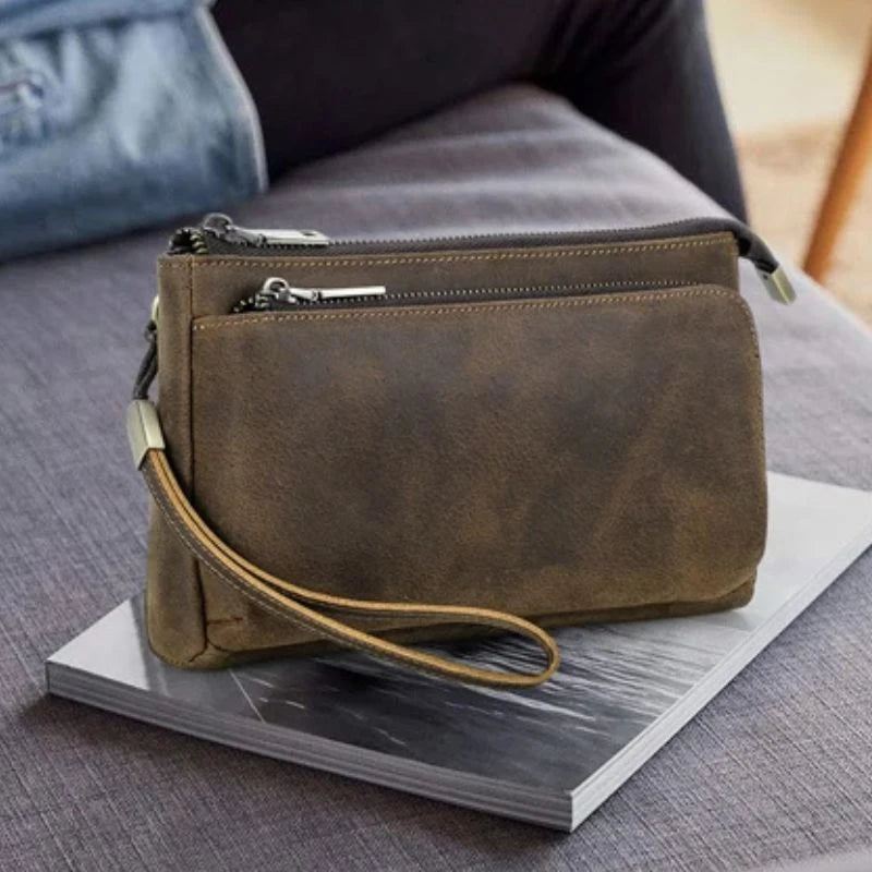 Brown leather clutch with eleant wrist strap, front view.