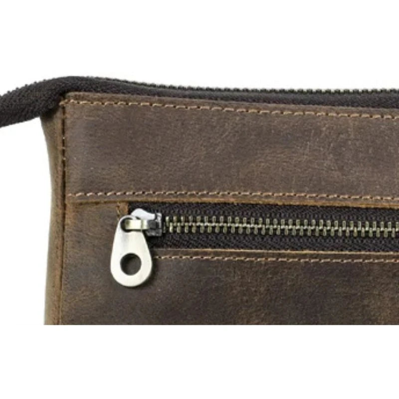 detailed view of a brown leather clutch showing the quality of the back zipper.