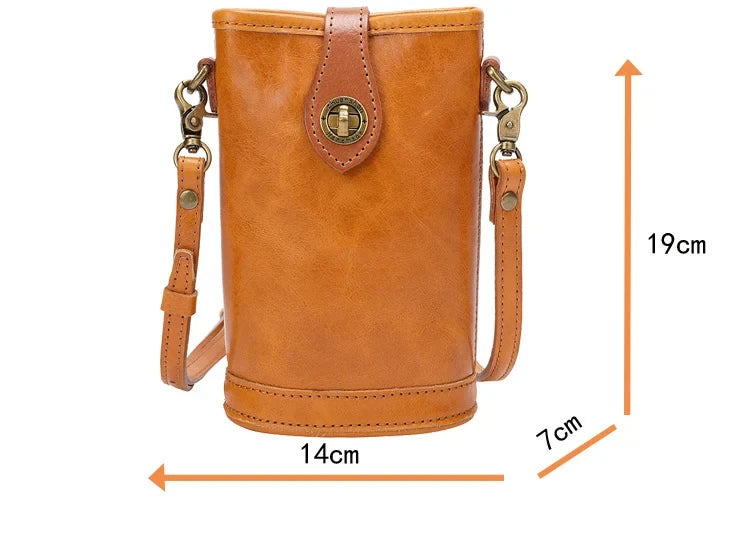 Crossbody style leather bag in brown color, measuring 14cm wide, 19cm high and 7cm deep, front view.
