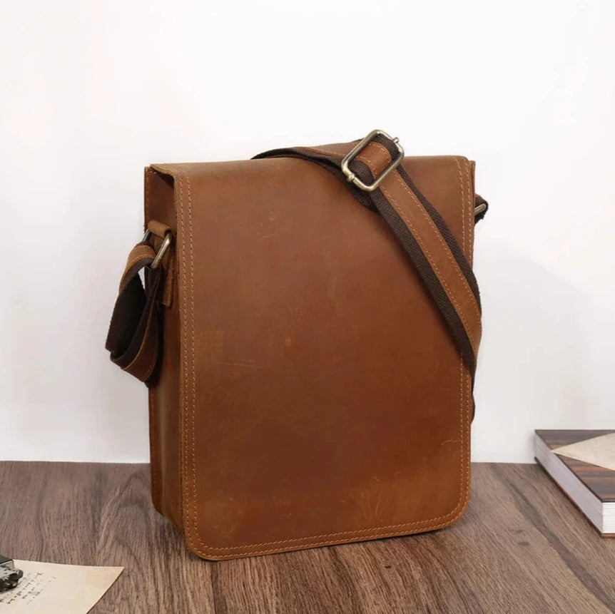 Brown leather crossbody bag, casual style, with minimalistic design and adjustable strap, front view.