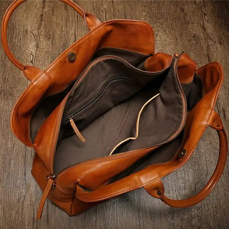 Interior view of a brown leather bag, showing its spacious and organized compartments and interior pockets.