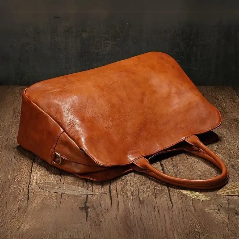 Brown leather bag with an elegant  design, ideal for daily use or travel. Stylish accessory with practical handles.