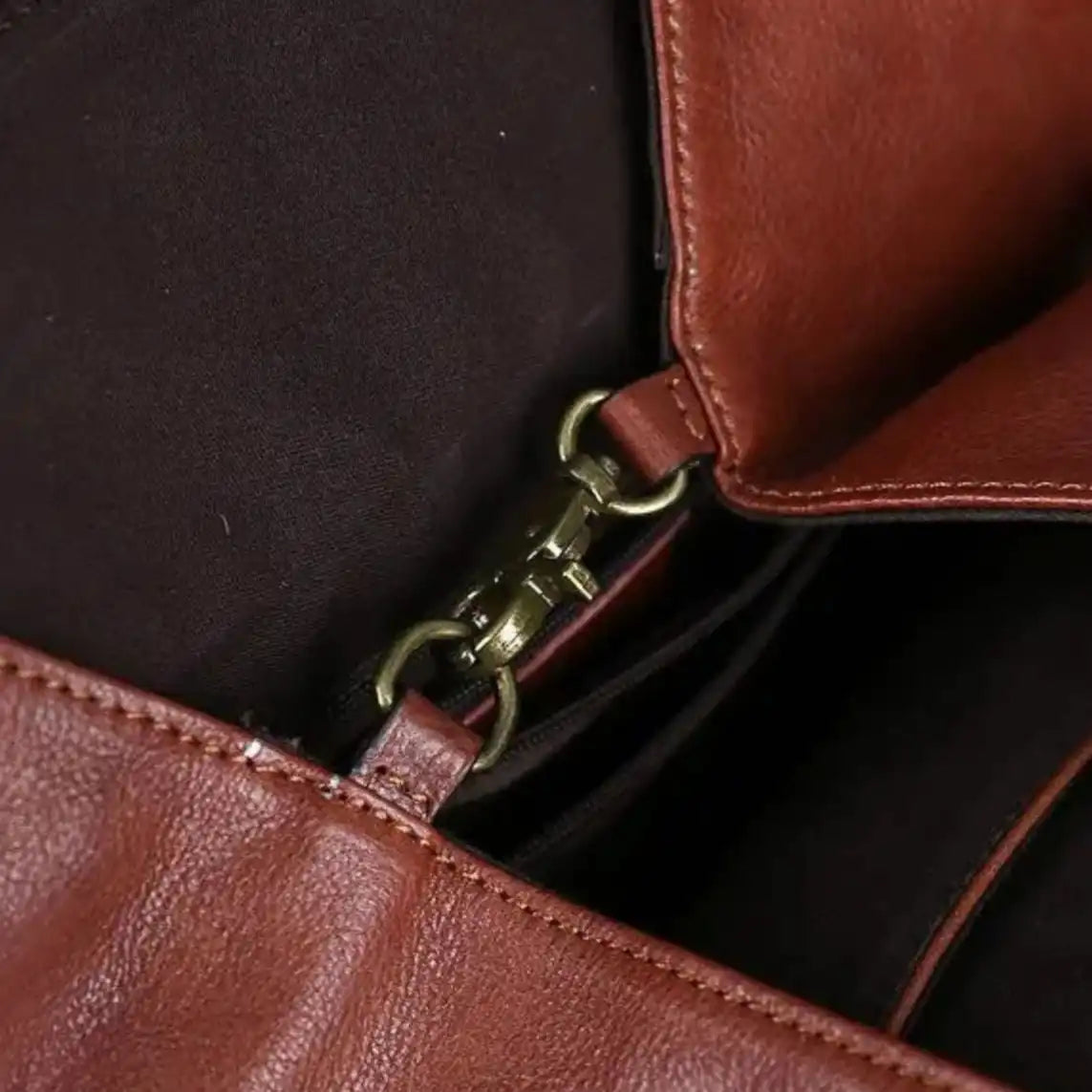 Close-up of a stylish brown leather bag interior showing the clasp and inner lining details.