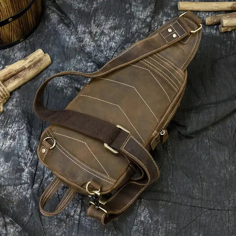 A stylish vintage leather shoulder bag with a zipper, double handles and adjustable strap, back view.