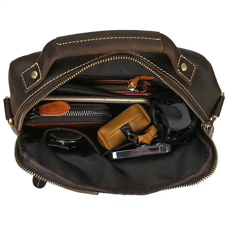 interior view of a leather bag, with various accessories organized such as wallets, a notebook, and other essential items.
