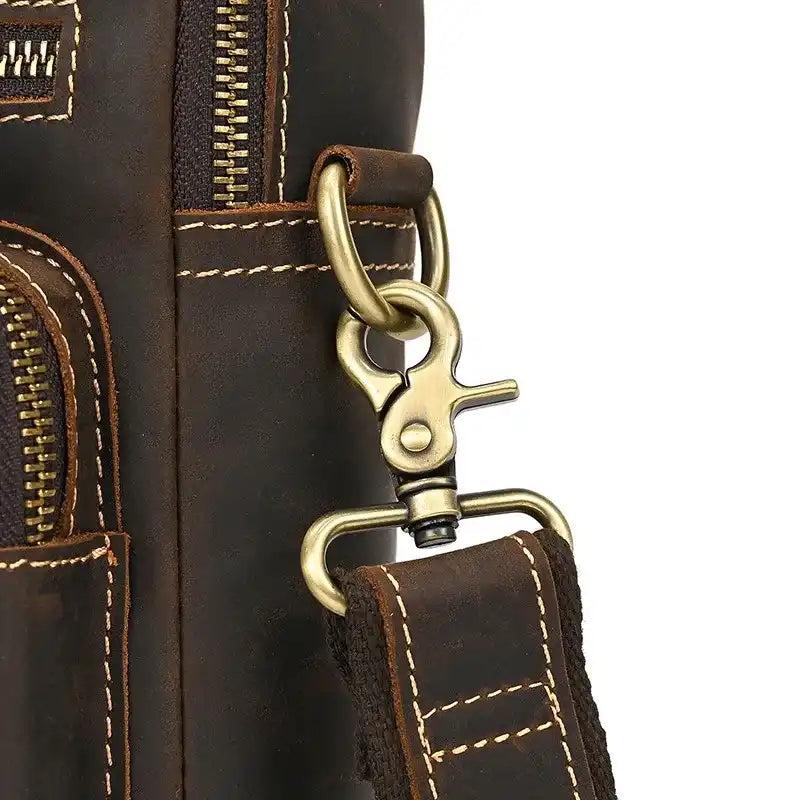 Detail of a brown leather clasp with light stitching, highlighting the buckle and handle of a classic style bag.