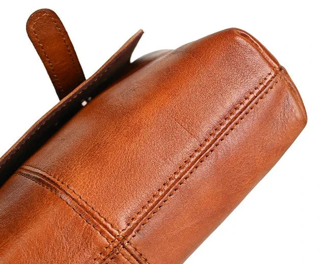 close up of a brown leather bag highlighting the stitching and finish.