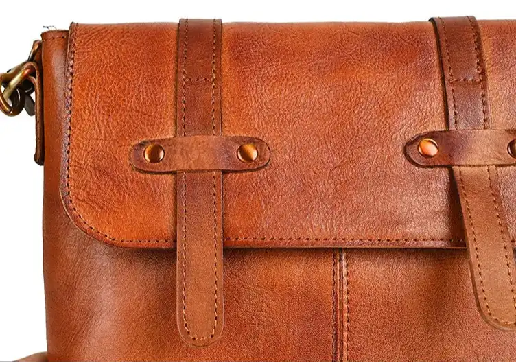 Vintage style brown leather purse with decorative straps.