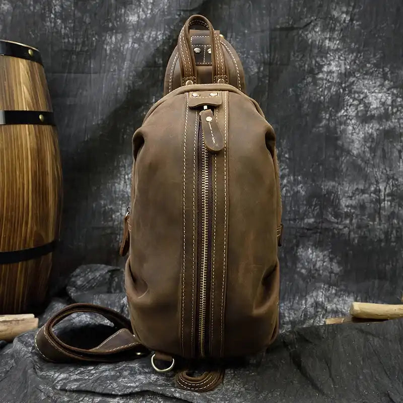 A stylish vintage leather shoulder bag with a zipper, soft handle and adjustable strap, front view.