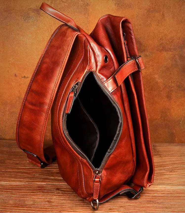 open brown leather crossbody bag with zippered compartment.