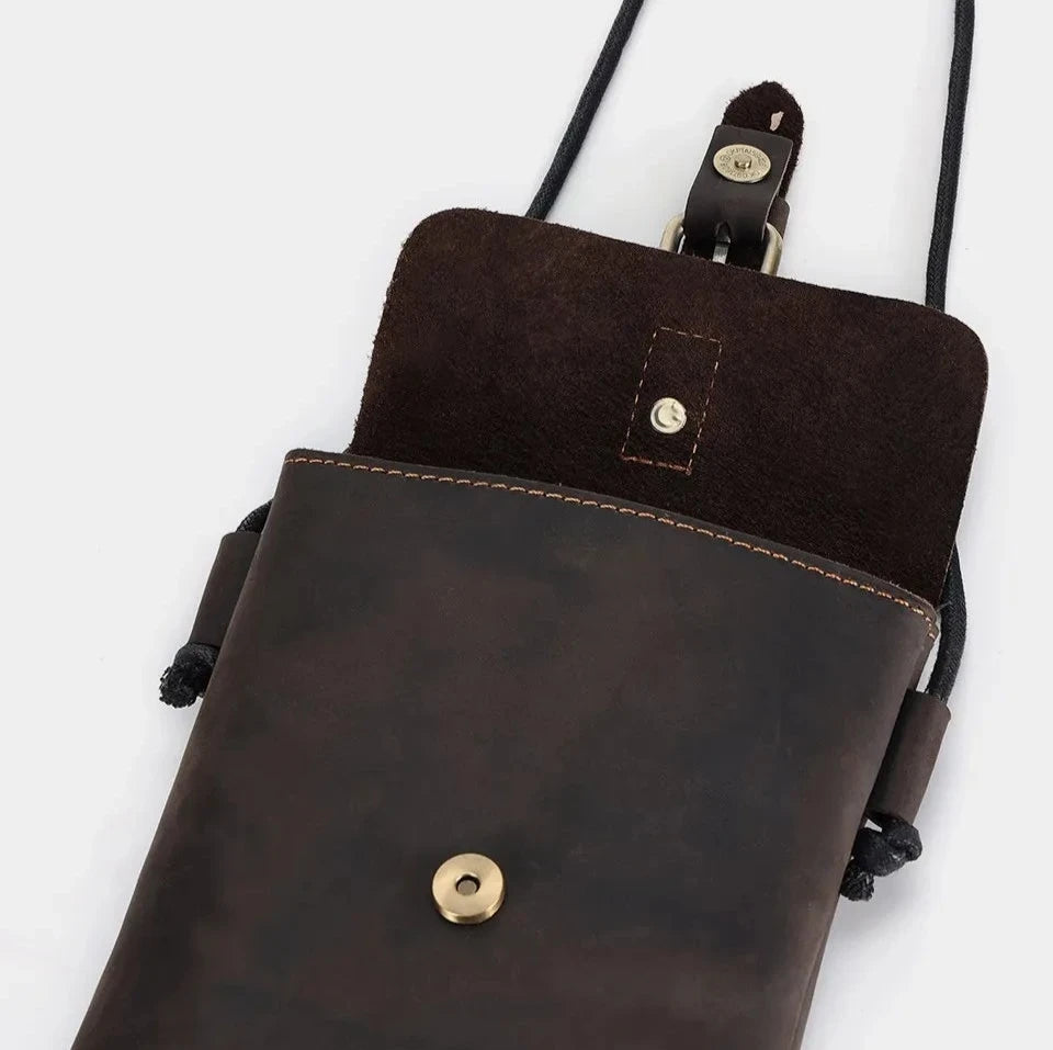 Stylish vintage brown leather crossbody bag with a suede flap and brass button.
