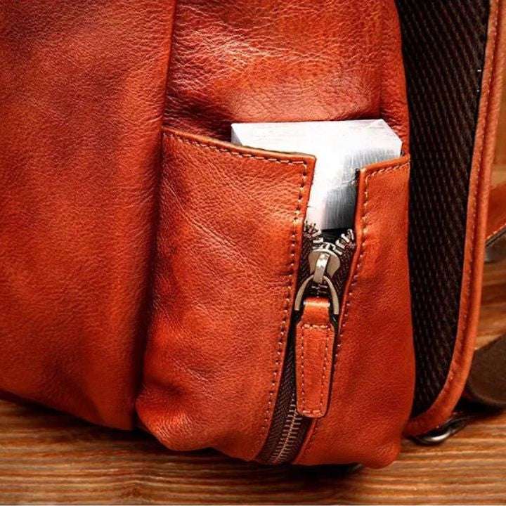 Detailed view of a brown leather bag showcasing its side zipper pocket.