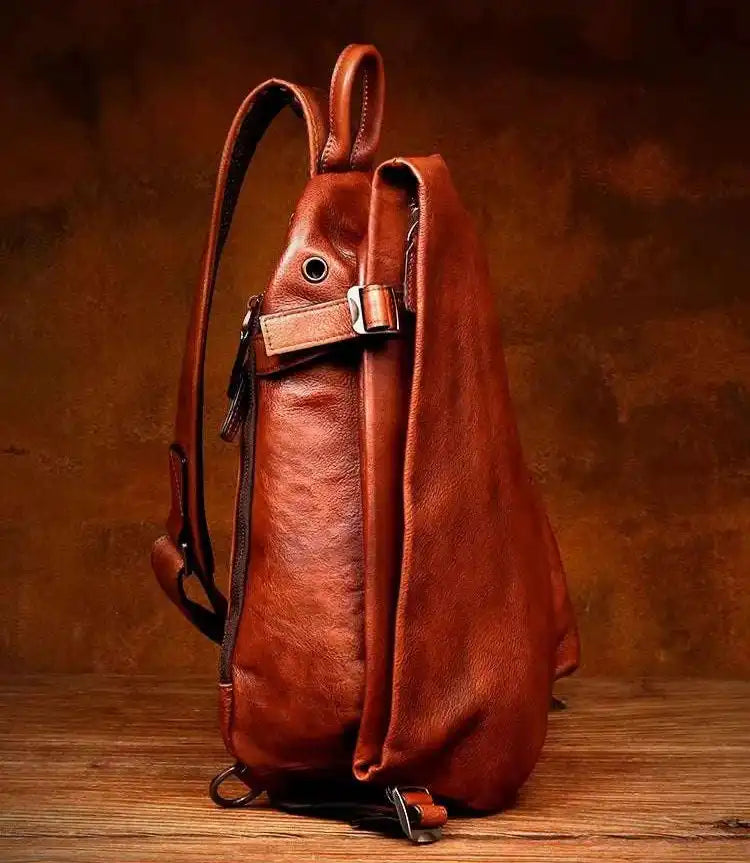 Side view of a vintage leather shoulder bag showcasing its rich brown color and unique design.