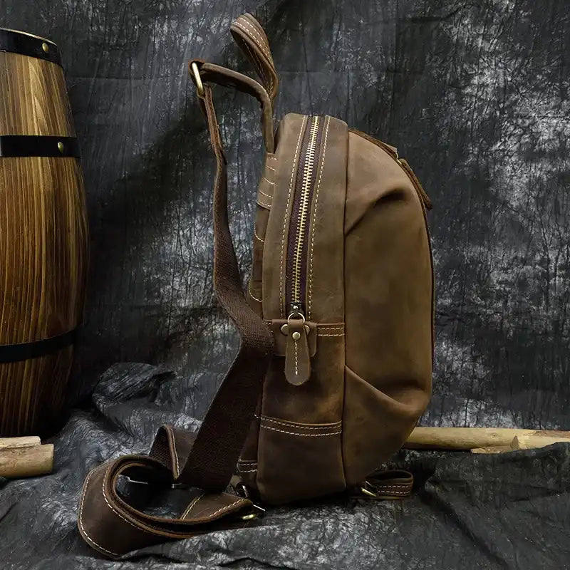 A stylish vintage leather shoulder bag with a zipper, soft handle and adjustable strap, side view.