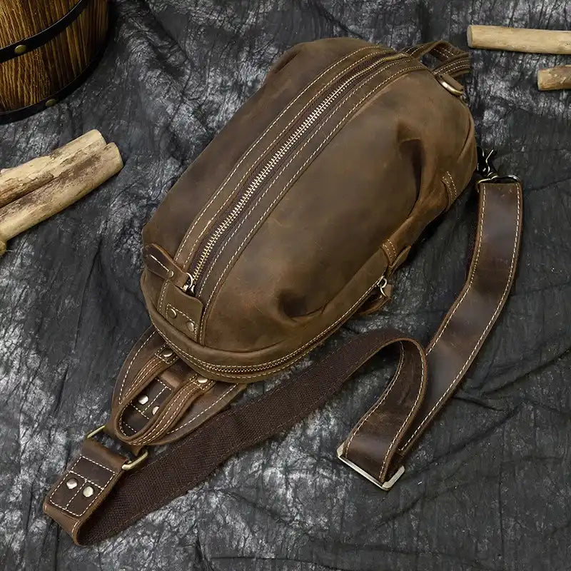 A stylish vintage leather shoulder bag with a zipper, double handles and adjustable strap, top view.