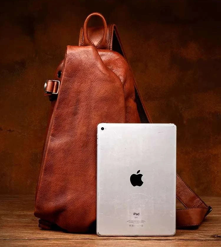 Brown leather shoulder bag next to an ipad for size comparison.