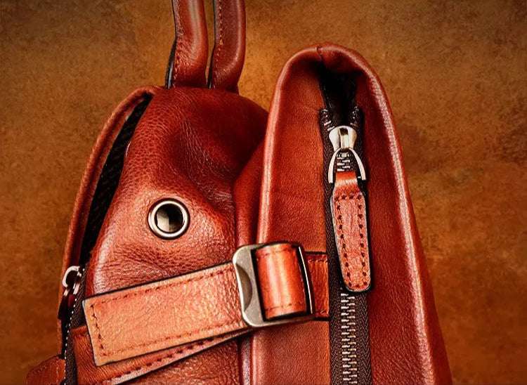 Detailed view of a brown leather bag with unique strap and zipper design.