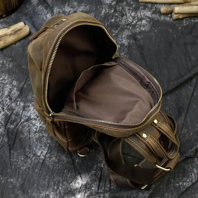Open brown leather bag with zipper, featuring a spacious interior with interior compartments.