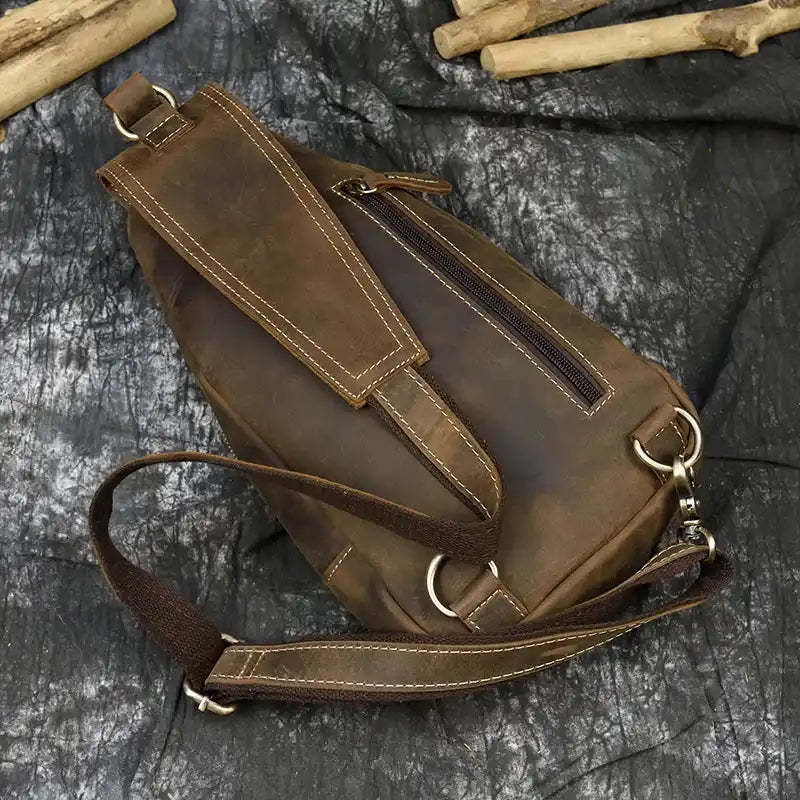 Stylish brown leather bag with an adjustable strap and back pocket, top view.