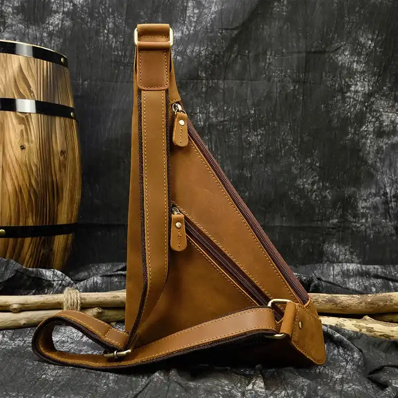 Stylish brown leather sling bag with multiple zippers - back view.