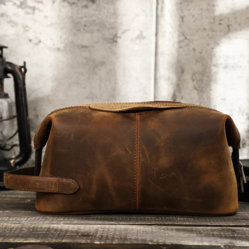 Brown leather toiletry bag with zipper closure, ideal for storing personal items, front view.