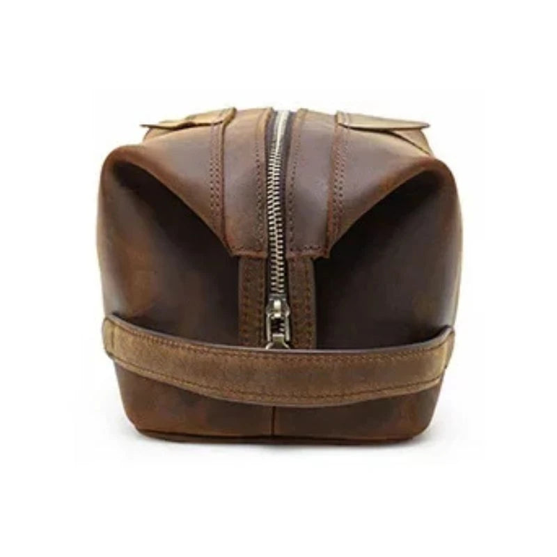 Brown leather toiletry bag with zipper closure and soft handle,side view.