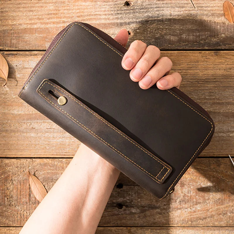 Close-up of a brown leather wallet with a wrist strap.