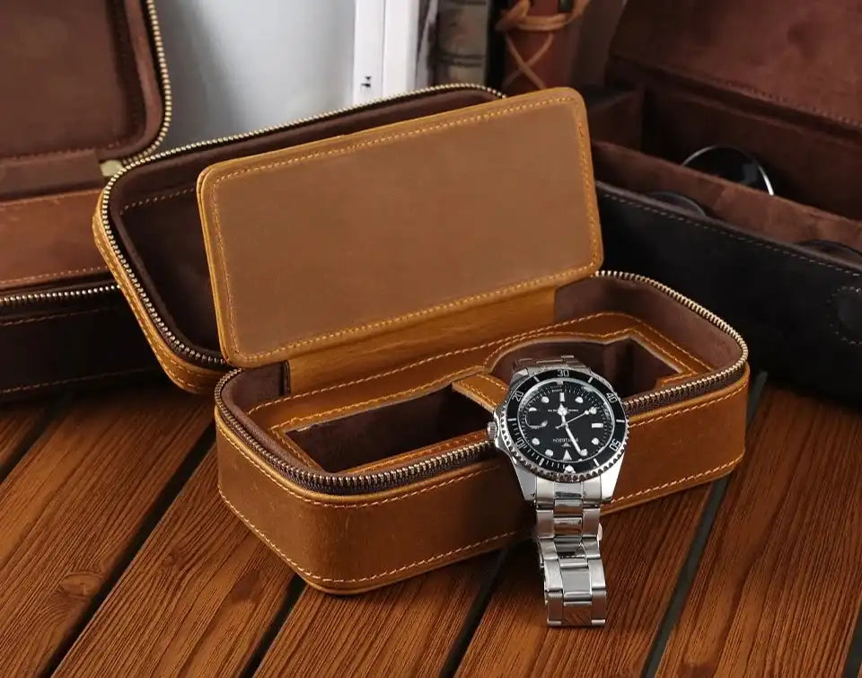 a brown leather watch box with a silver wristwatch on a wooden surface. Ideal for watch storage.