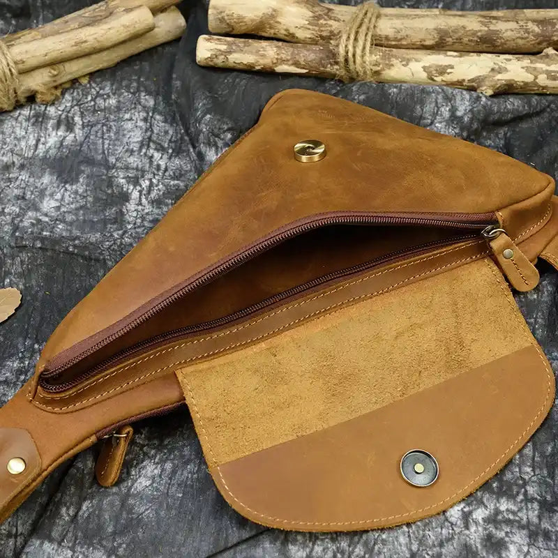 Open view of a leather crossbody bag showcasing its interior and zipper.