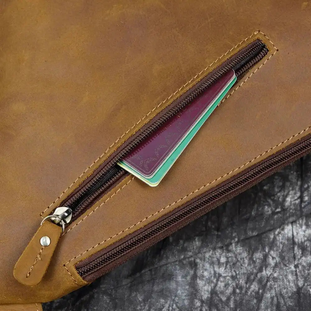Detailed view of a brown leather bag showcasing the zipper and cards.