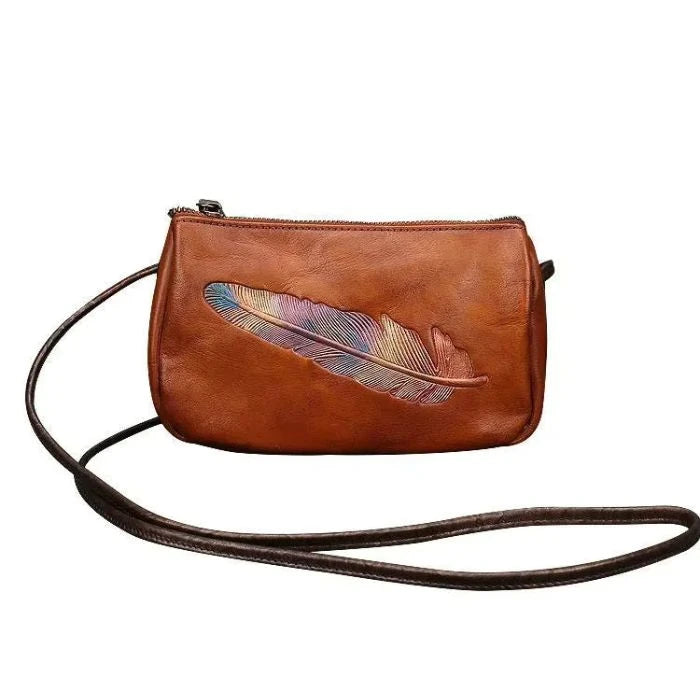 Brown leather crossbody bag with colorful feather embossed detail with long strap, front view.