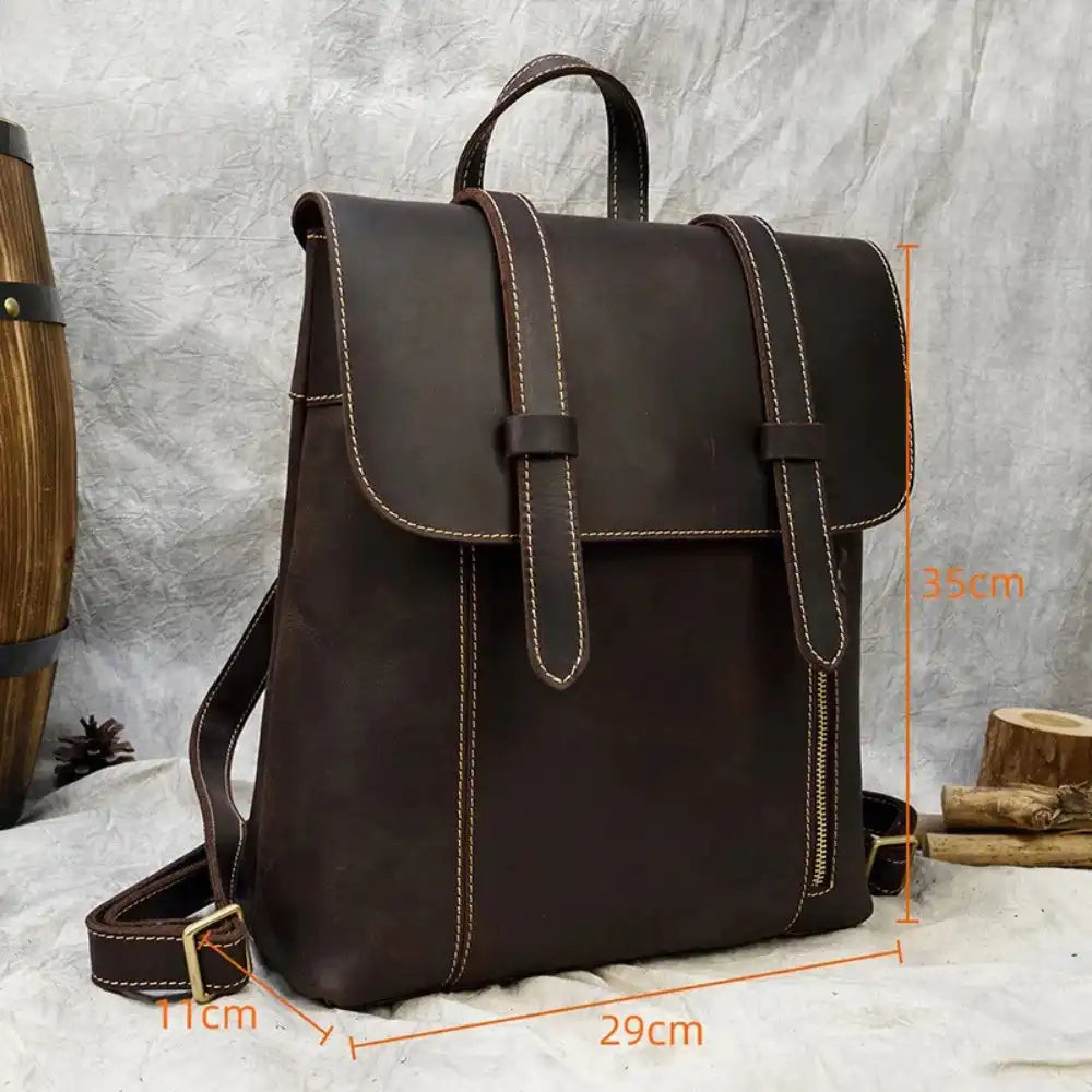 Coffee brown leather backpack measuring 29 cm wide, 35 cm high and 11 cm deep, front view.