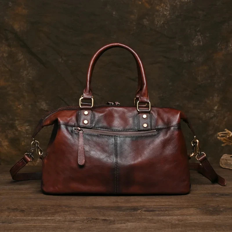 Vintage style coffee brown leather bag with handles and large compartment, back view. 