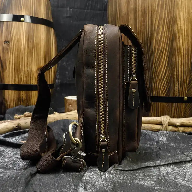 Coffee brown leather bag, casual style, featuring large compartments and adjustable strap, side view.