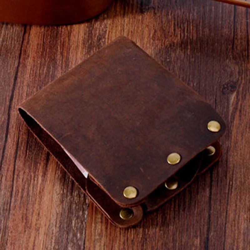 coffee brown leather wallet with metal details on a wooden table, front view.