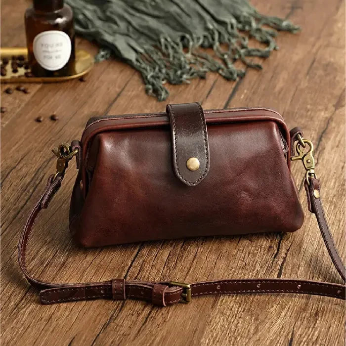 Coffee brown leather shoulder bag with leather adjustable strap and snap closure, front view.