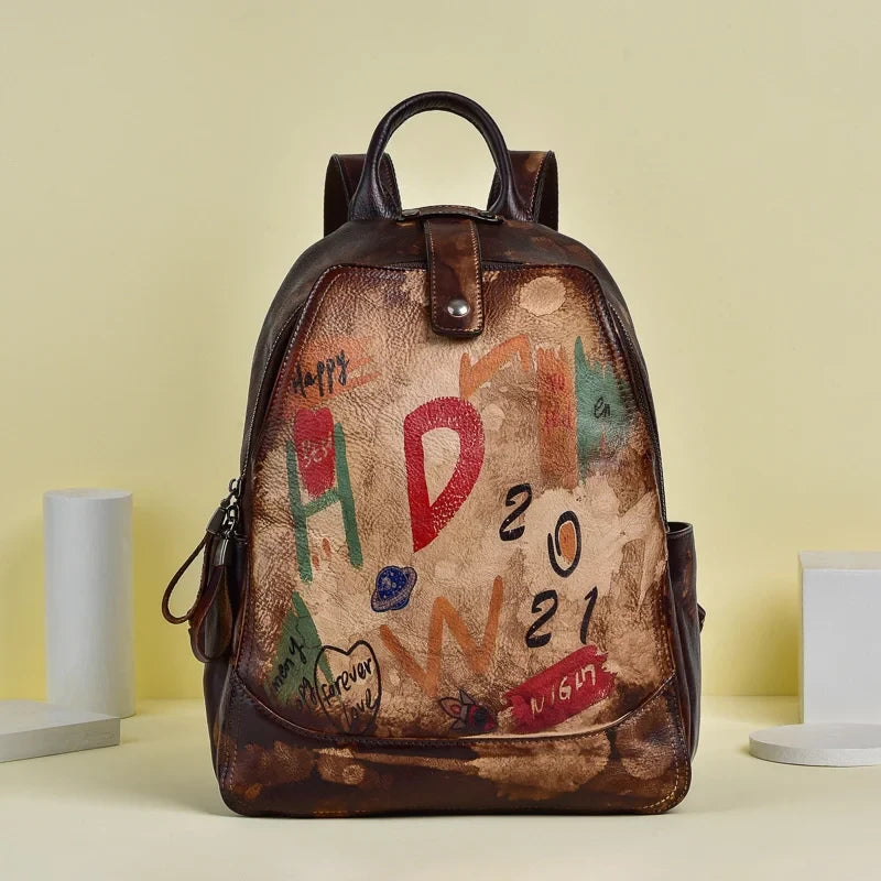 Brown leather backpack with an artistic design filled with vibrant colors and drawings, front view.