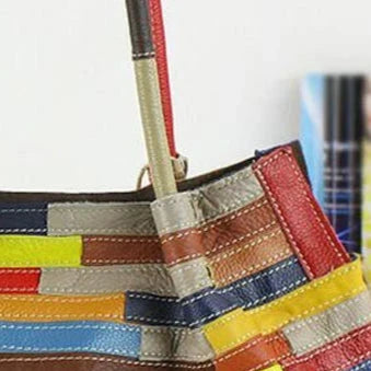 close-up view of a colorful leather bag with sturdy handle.