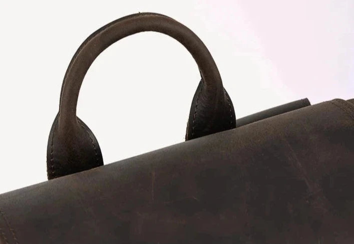 Close-up of a brown vintage leather bag handle showcasing its craftsmanship.