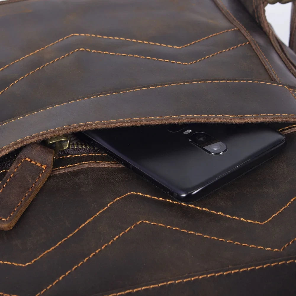 close-up of a stylish brown leather bag featuring a smartphone pocket.